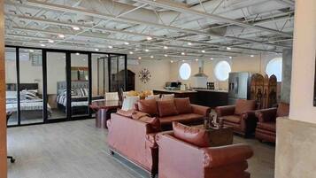 A spacious living area with leather sofas, a coffee table, and a kitchen area in the background.