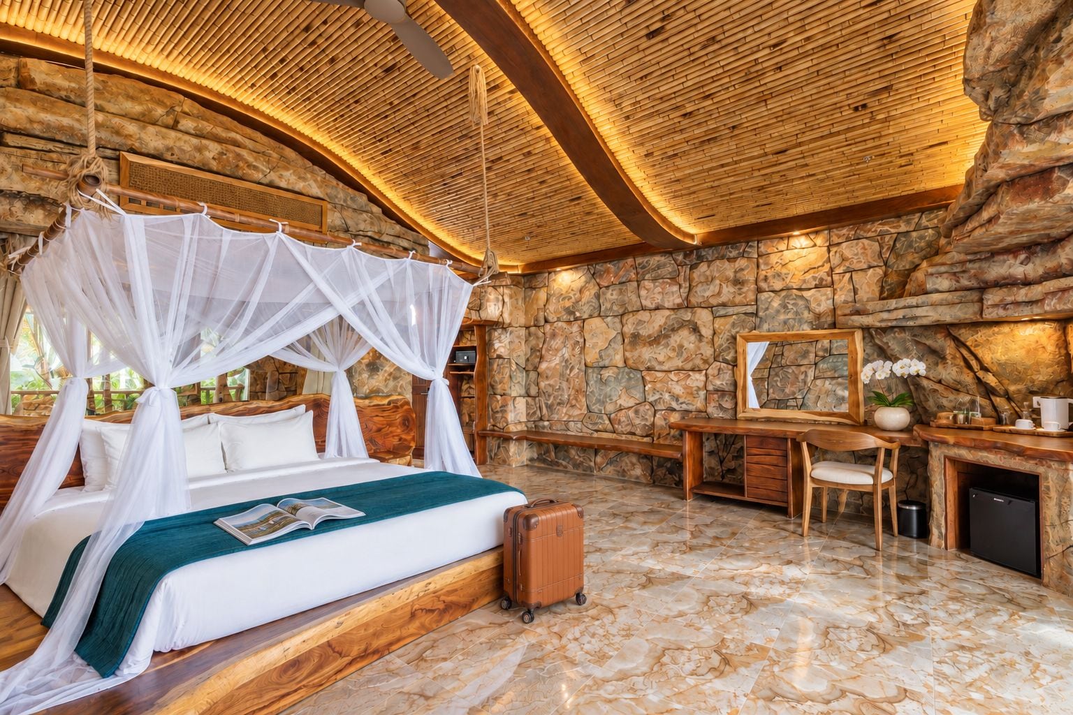 A bedroom with a canopy bed, stone walls, a desk, and a mirror.