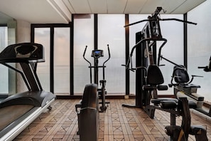 Ein Fitnessstudio mit Laufbändern, Crosstrainern und Kraftgeräten.