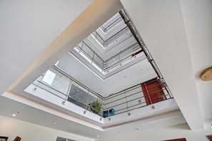 Ein mehrgeschossiges Atrium mit Glasgeländern und einer zentralen Treppe.