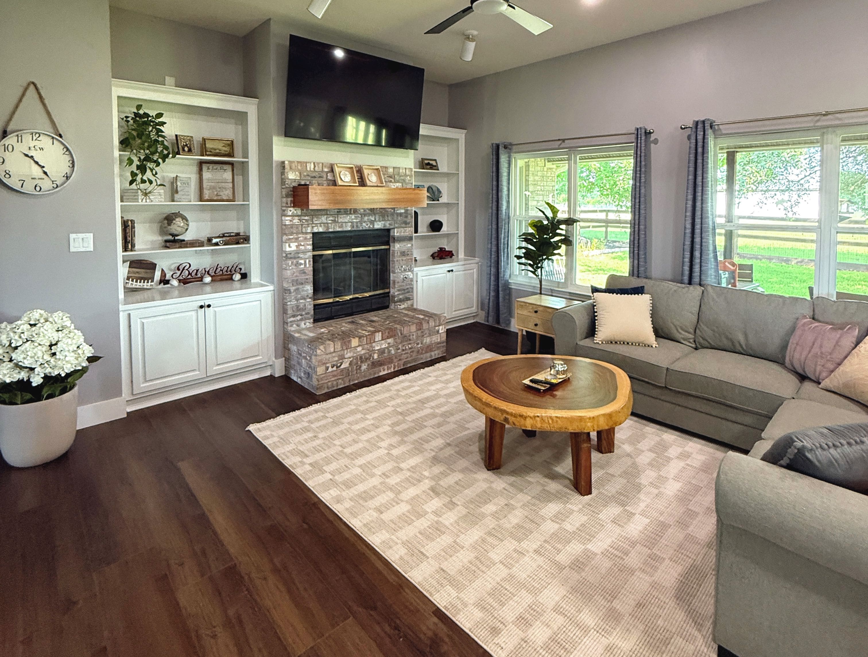 A living room with a fireplace, a sofa, a coffee table, and a television.