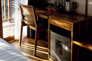 A wooden desk with a GEA refrigerator, a chair, and a kettle on the table. - Semara Gangga Beach Retreat (Tabanan)