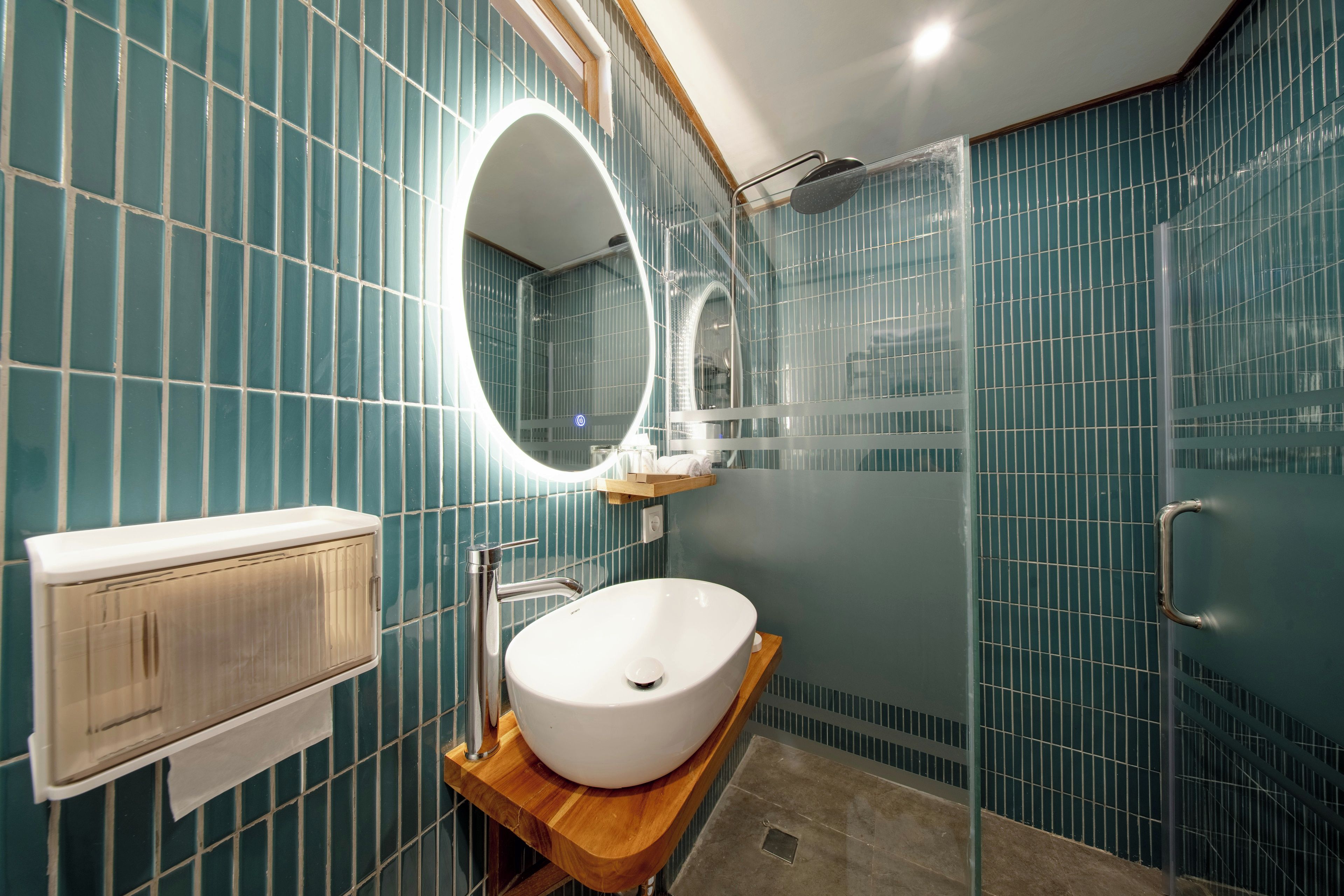 Un baño con lavamanos blanco, un espejo y cabina de ducha.