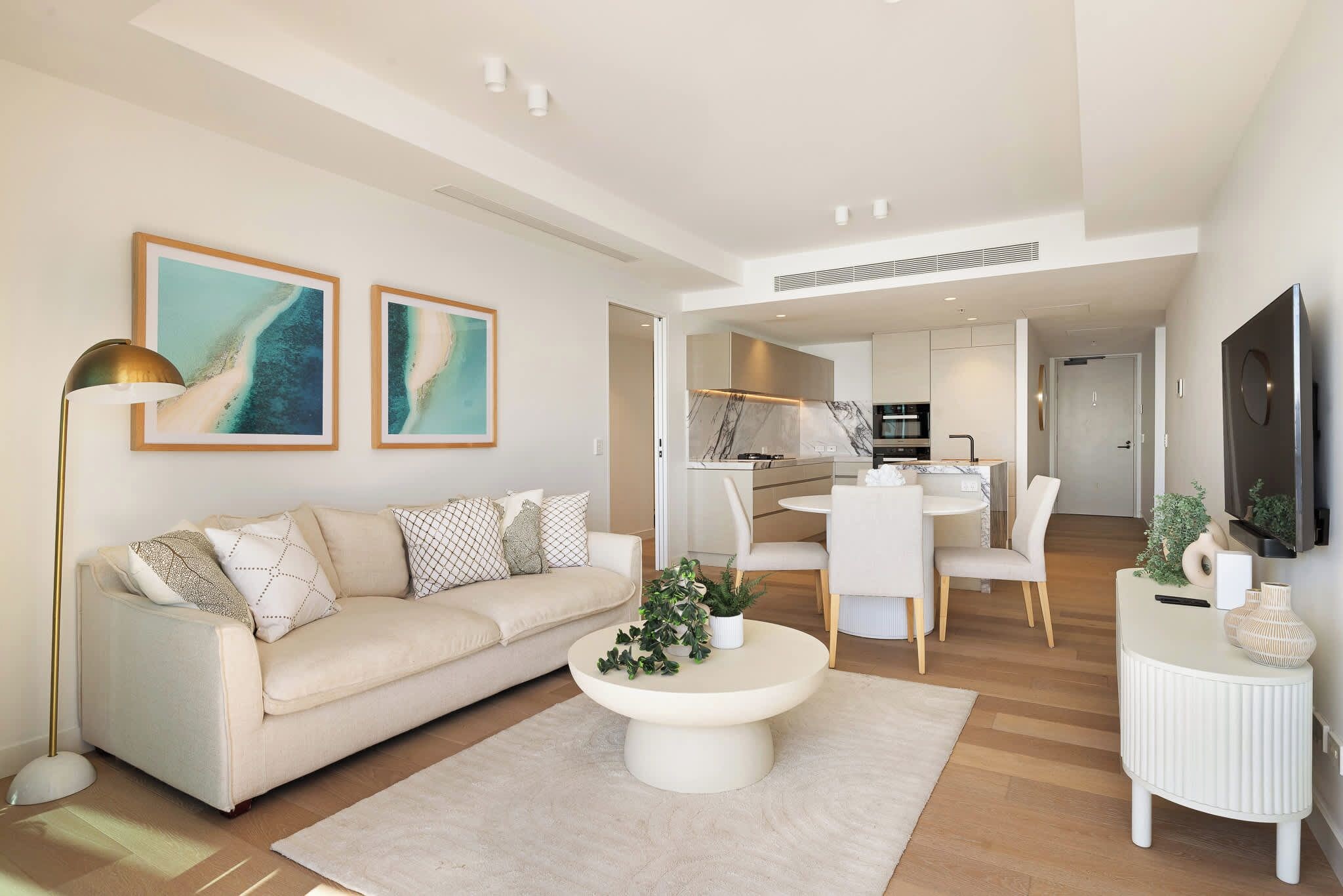 A modern living room with a sofa, coffee table, and artwork.