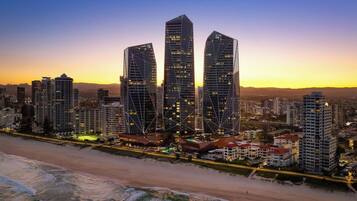 A coastal cityscape with modern high-rise buildings, a beach, and a clear sky.