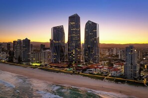 A coastal cityscape with modern high-rise buildings, a beach, and a clear sky. - Jewel Designer Residence | Direct Ocean Views (Surfers Paradise)