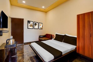 A hotel room with a bed, a television, a coffee maker, and framed artwork on the wall. - Collection O Kasarsai Dam Pune (Paud)