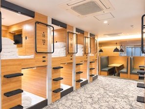 Habitación de hotel con literas, zona de estar y televisor.