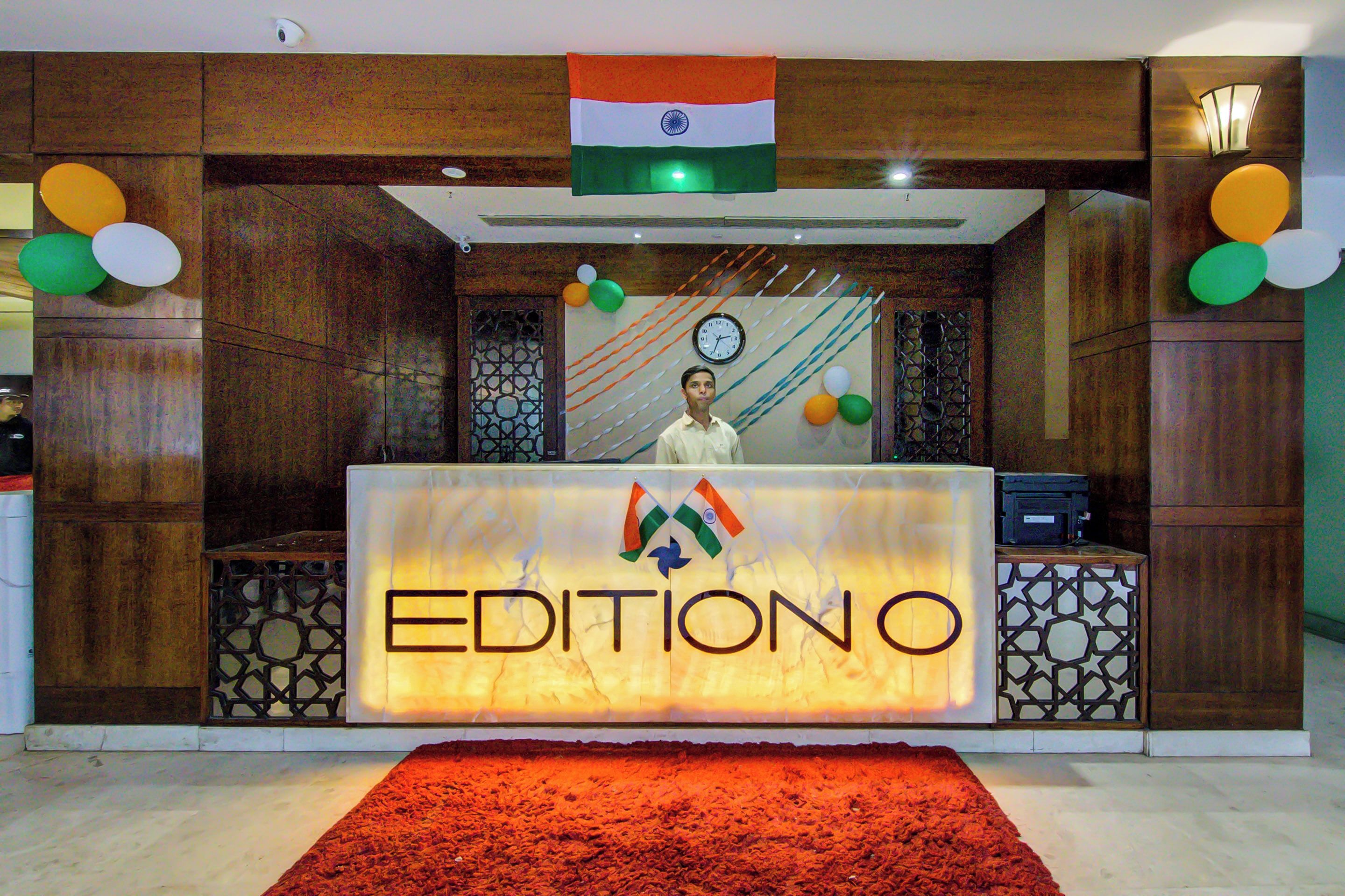 A reception desk with a sign reading 'EDITIONO' and an Indian flag above it.