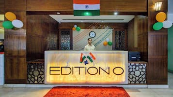 A reception desk with a sign reading 'EDITIONO' and an Indian flag above it.