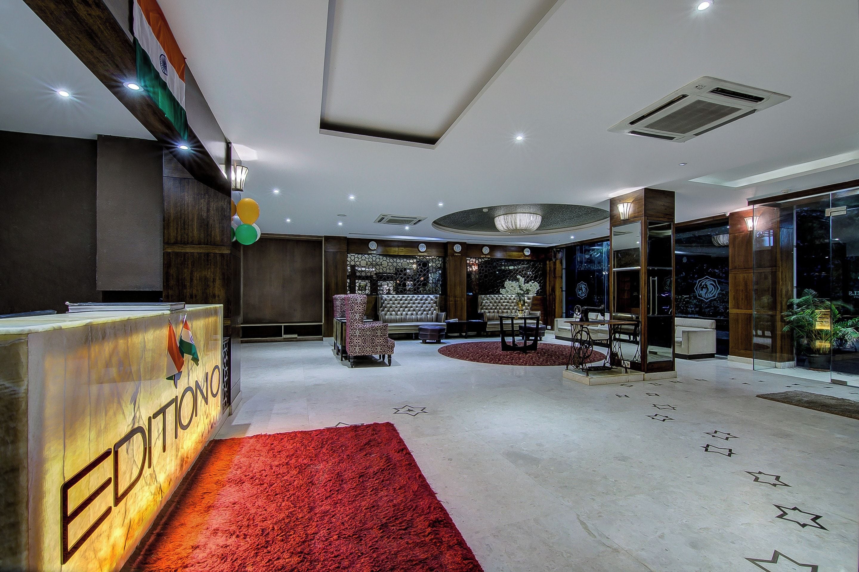 Un vestíbulo de hotel con mostrador de recepción, zona de estar y un candelabro.