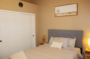 A bedroom with a bed, a nightstand, a lamp, and a door. - Inside Anthem master plan community. 8 minute drive to TSMC. Close to I-17! (Phoenix)