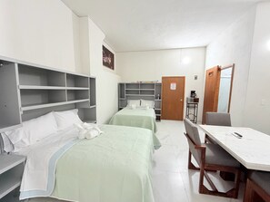 A hotel room with two beds, a desk, and a chair. - Cathedral Centro Histórico D18 (Guadalajara)