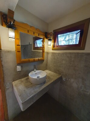 A bathroom with a round sink, a wooden-framed mirror, and a small window with a view of trees. - Sandy Shores 1A y 1B (La Paz)