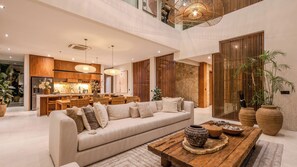 A modern interior with a sofa, dining area, kitchen, and a staircase. - Five Palms Villa by Elite Havens  (Mengwi, Badung)