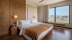 Ein modernes Schlafzimmer mit einem großen Bett, Holzvertäfelung, einer Bank am Fenster und Blick auf Gebäude.