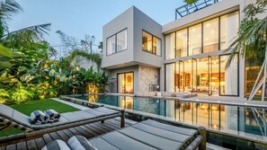 A modern house with a swimming pool, outdoor seating, and lush greenery. - Five Palms Villa by Elite Havens  (Mengwi, Badung)
