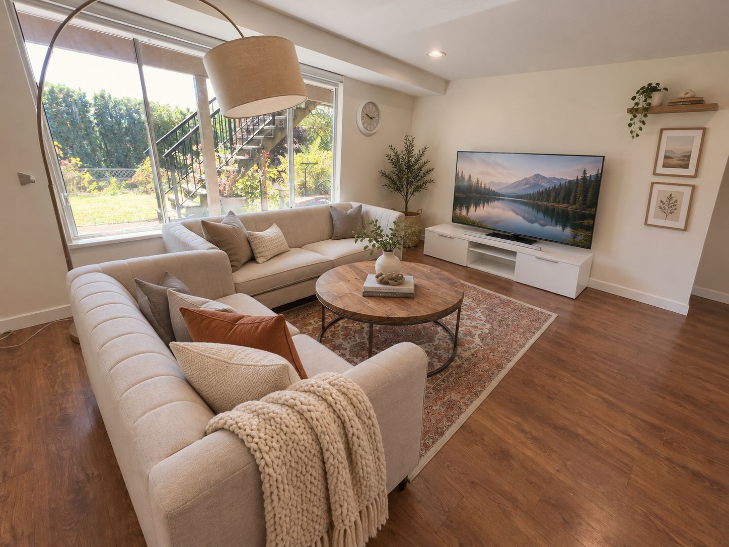 A modern living room with a sectional sofa, a coffee table, and a flat-screen TV.