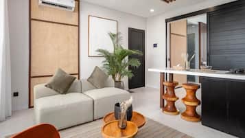 A modern living room with a sofa, a coffee table, and a dining area with a counter.
