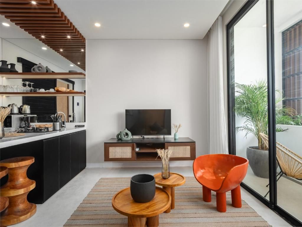 A modern living room with a TV, wooden furniture, and a large window.