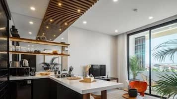 A modern kitchen with a central island, built-in appliances, and a large window providing a view of the outdoors.