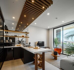 Una cocina moderna con una isla central, electrodomésticos integrados y un amplio ventanal con vistas al exterior.