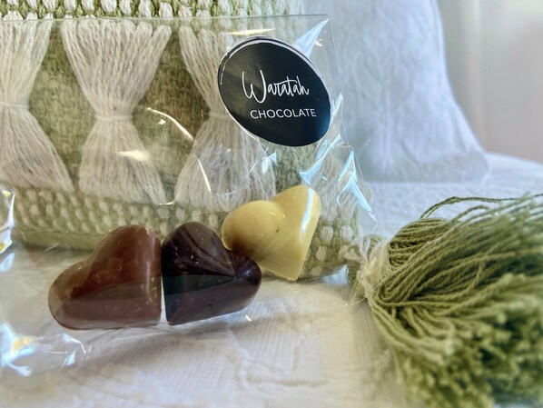 A package labeled 'Wawrath CHOCOLATE' with heart-shaped chocolates and a green knitted item.
