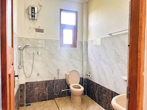 Ein Badezimmer mit Toilette, Dusche und einem Fenster.