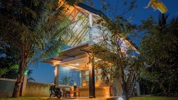 A building with a covered patio, a statue, and a scooter parked outside.