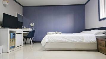 Un dormitorio con cama, escritorio, silla, cómoda y ventana.