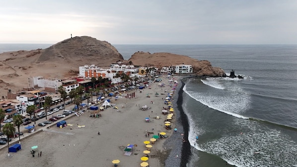 Une ville côtière avec une plage, des bâtiments et un phare.