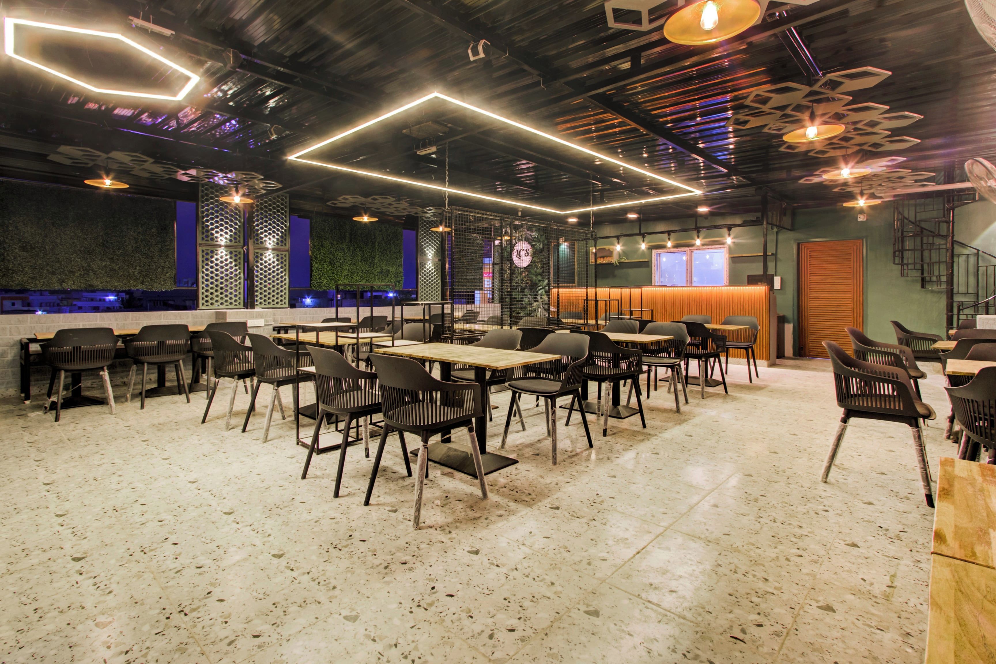 Un interior de restaurante moderno con diversas opciones de asientos, incluyendo mesas y sillas, y una zona de bar.