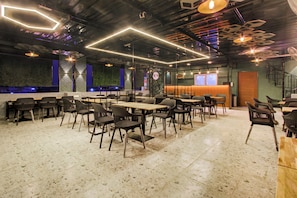 Ein modernes Restaurantambiente mit verschiedenen Sitzmöglichkeiten, darunter Tische, Stühle und eine Bar.