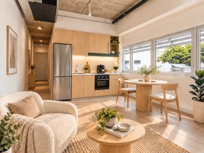 A modern kitchen with a refrigerator, oven, and sink, a dining area with a table and chairs, and a living room with a sofa and a coffee table. - Business Stay 2-Bed Apartment Darwin City (Darwin City)
