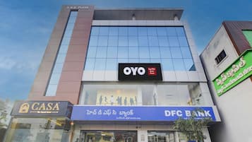 A multi-story building with a prominent OYO logo on the facade, indicating a hotel or guest house.