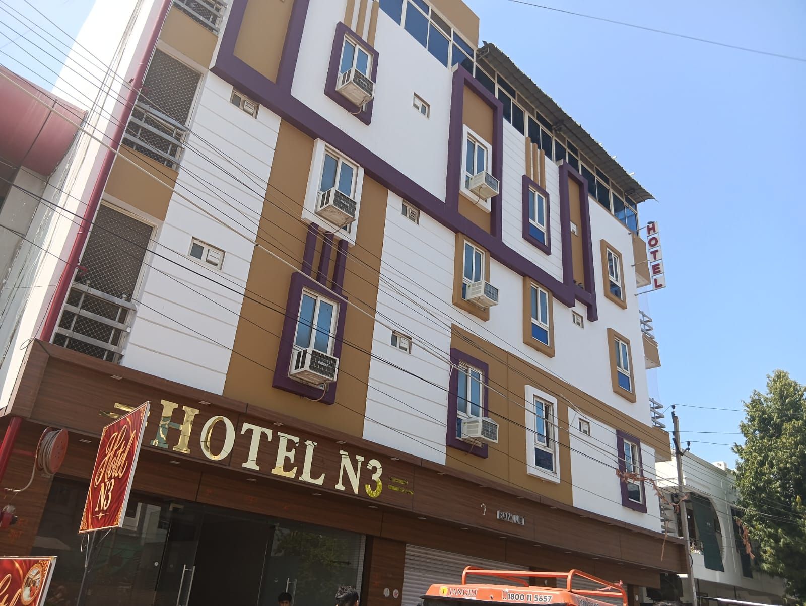 A multi-story hotel building with a sign reading 'HOTEL N3' and a visible entrance.