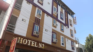 A multi-story hotel building with a sign reading 'HOTEL N3' and a visible entrance.
