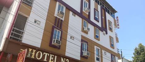 Un edificio de hotel de varios pisos con un cartel que dice 'HOTEL N3' y una entrada visible.