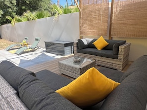 En terrasse med sofa, opbevaringsskab og et bord.