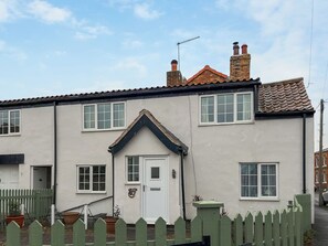 A two-story house with a white exterior, a front door, and a small porch area. - 2 bedroom accommodation in Sherburn (Sherburn)