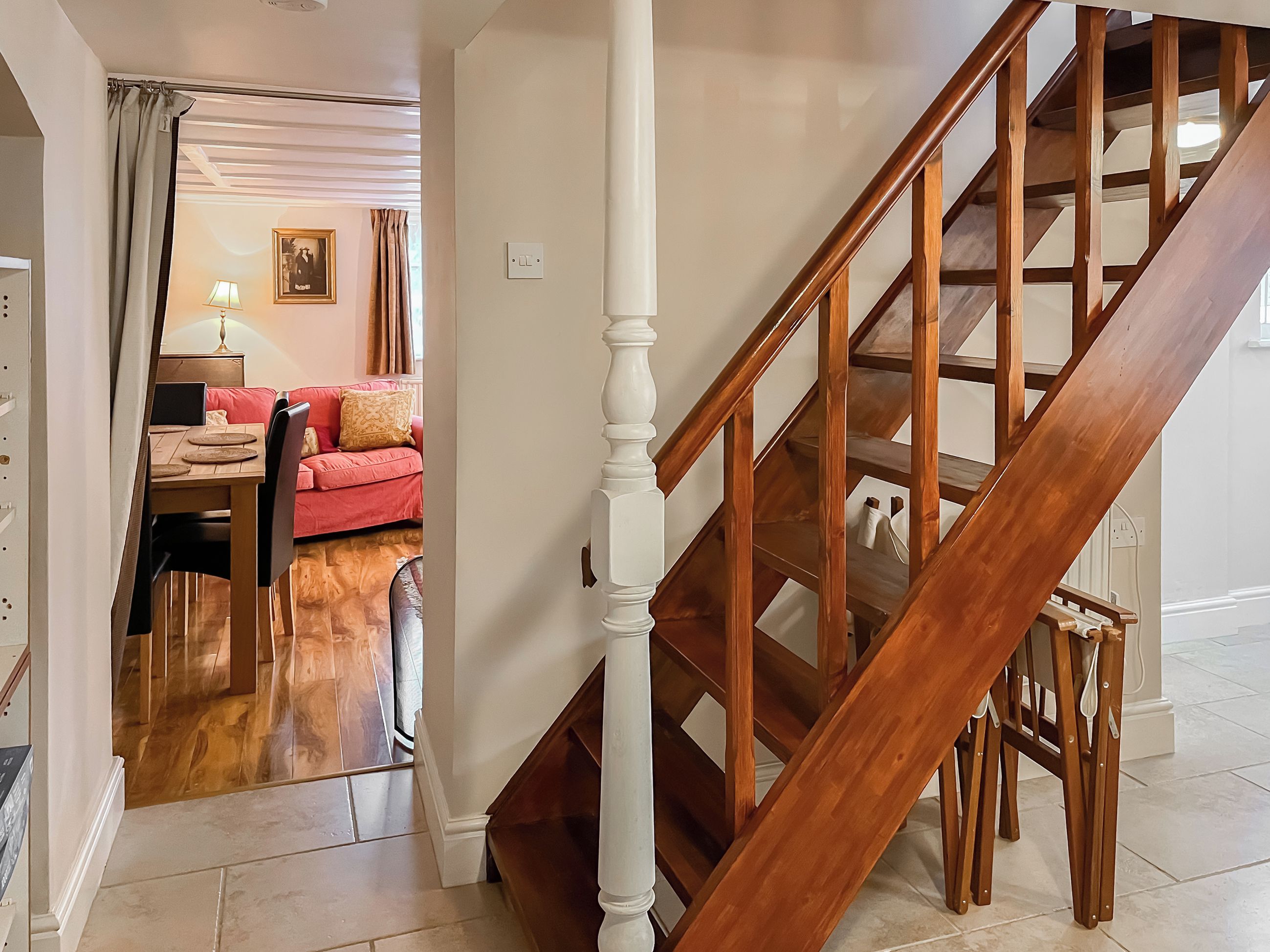 A wooden staircase with a white balustrade leading to a landing.