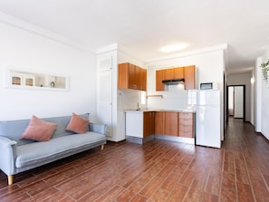 A compact living space with a kitchenette, a sofa, and a hallway. - CHL La Plaza Amazing Views Tenerife (Santa Ursula)