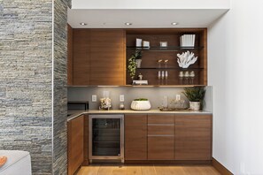 Eine moderne Küche mit Holzausstattung, einem integrierten Kühlschrank und einer Arbeitsplatte mit Dekoration.