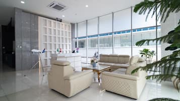 A modern living room with a sofa set, a coffee table, and a reception desk.