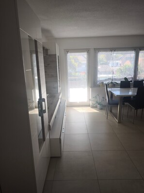 A modern kitchen with a dining area, a staircase, and a view of the outside. - Apartment 'Mamone' with Balcony and Wi-Fi (Gottmadingen)