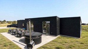 A modern building with a patio area featuring outdoor seating and a barbecue grill. - VillaVilla 1014 - Gjerrild, Østjylland (Granaa)