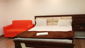 Un dormitorio moderno con cama, sofá rojo y ventilador de techo.