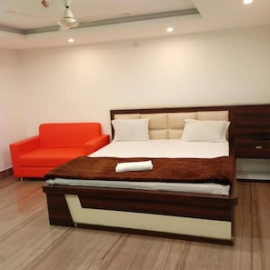 Ein modernes Schlafzimmer mit einem Bett, einem roten Sofa und einem Deckenventilator.