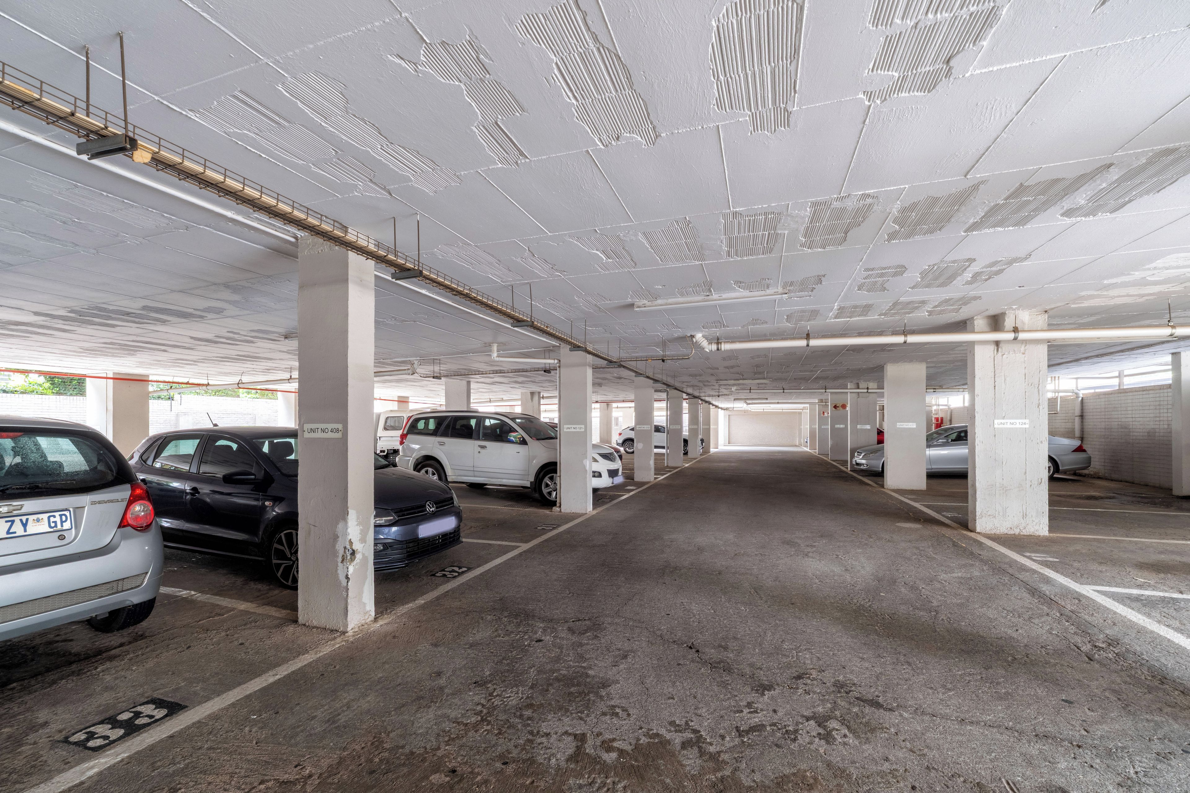 Un estacionamiento de varios niveles con pilares de hormigón y una distribución en cuadrícula de espacios.