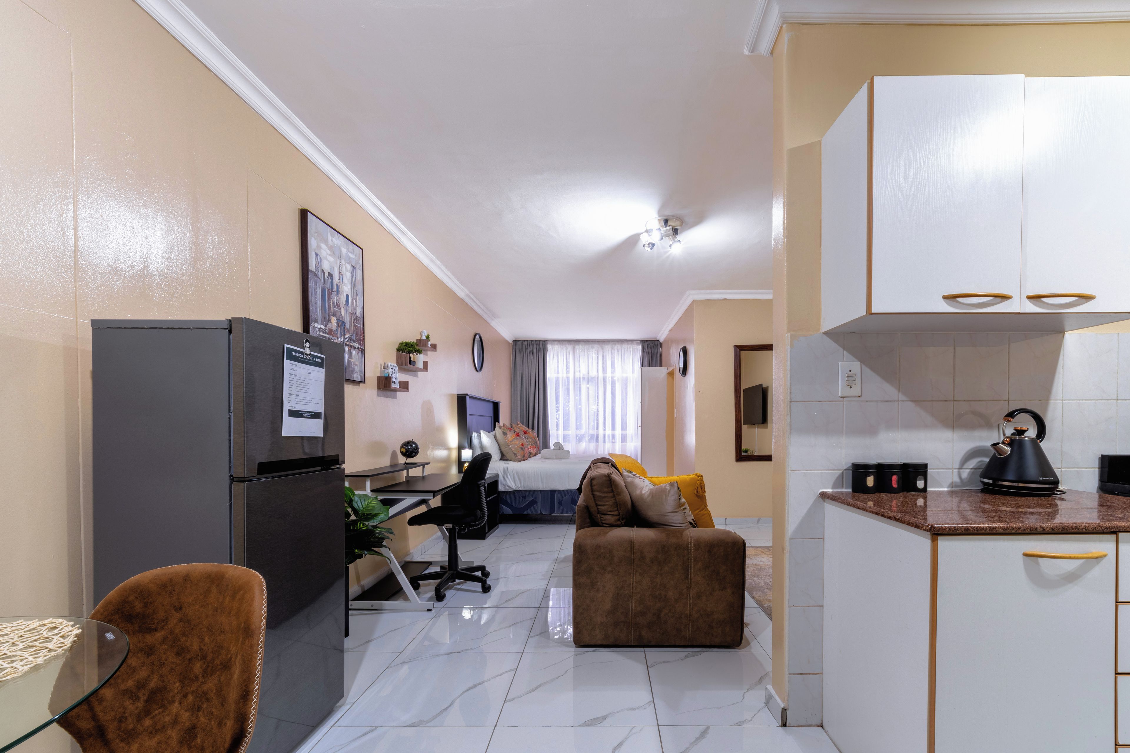 Un espacio habitable compacto con kitchenette, comedor y un dormitorio.